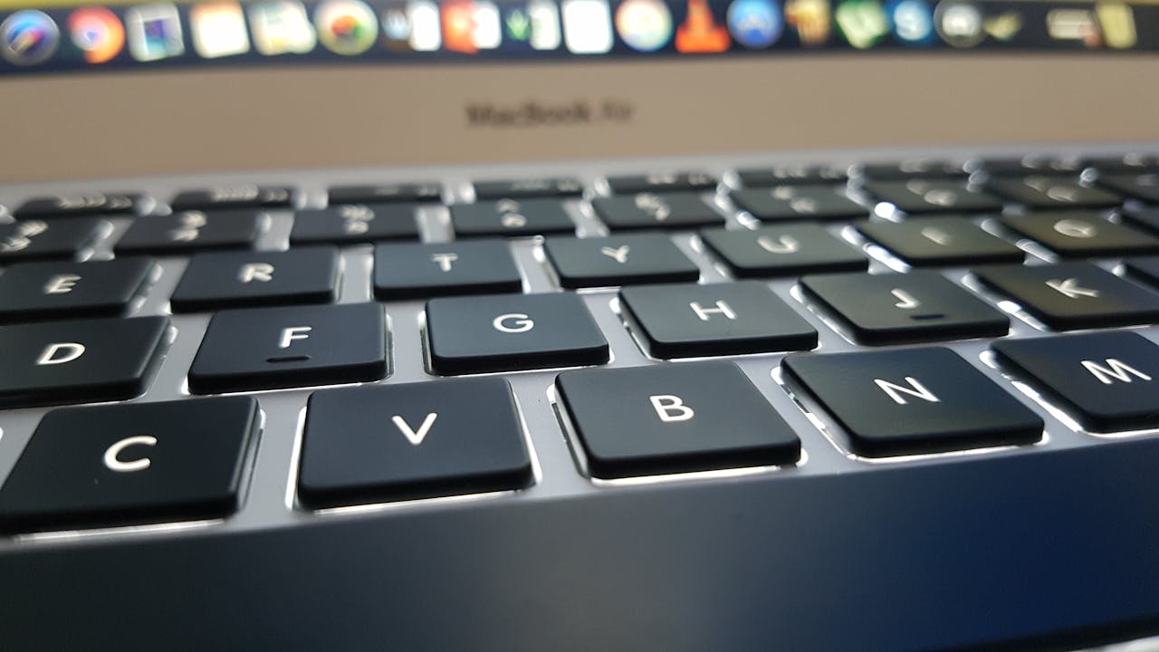 Detailed view of a MacBook Air keyboard with focus on keys, emphasizing technology and design.